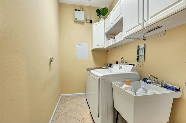 clothes washing area with cabinets, sink, washer and clothes dryer, and light tile patterned flooring