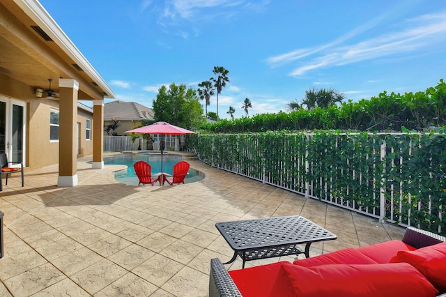 view of patio featuring a fenced in pool, ceiling fan, and an outdoor living space