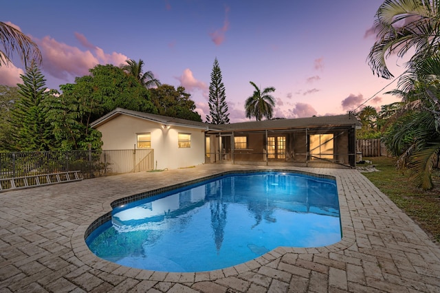 pool at dusk with a patio