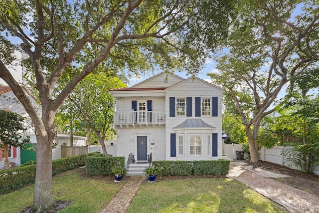 view of front of home featuring a balcony and a front lawn