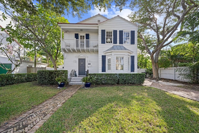 view of front of property with a balcony and a front lawn