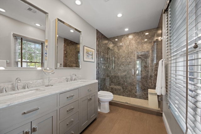 bathroom featuring tile patterned floors, a shower with door, vanity, and toilet