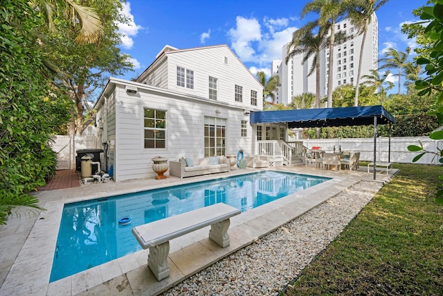 rear view of house featuring an outdoor hangout area, a fenced in pool, and a patio area