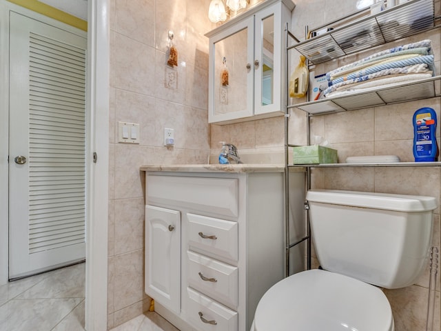 bathroom with vanity, tile walls, and toilet