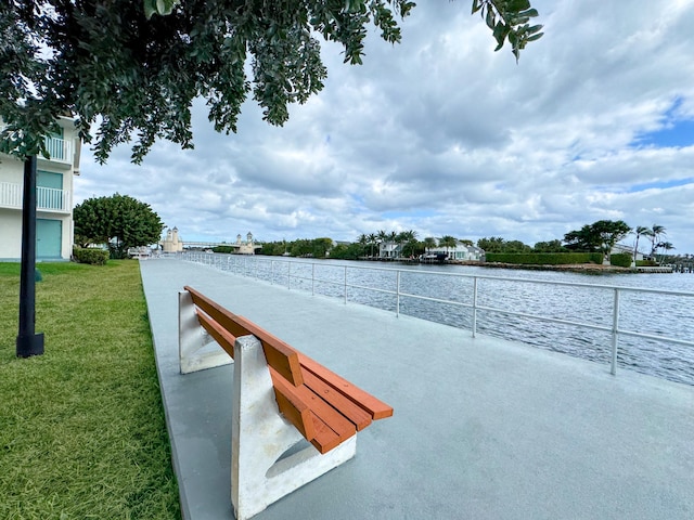 view of property's community with a lawn and a water view