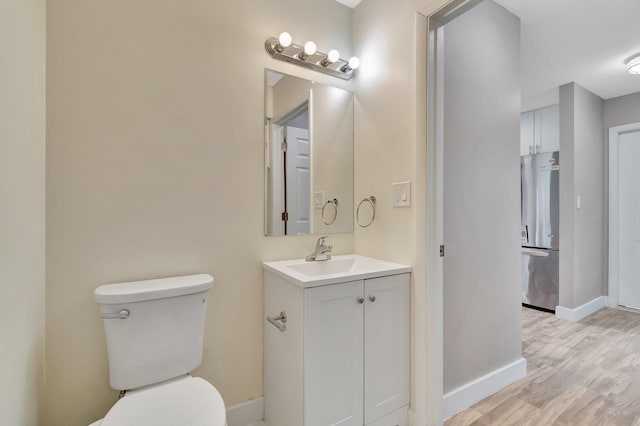 bathroom featuring vanity, wood-type flooring, and toilet