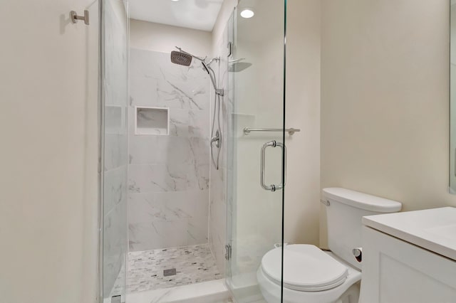 bathroom featuring vanity, an enclosed shower, and toilet