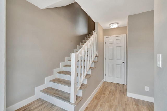 stairs featuring hardwood / wood-style floors