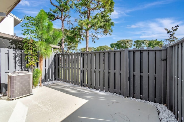 view of gate featuring a patio area and central air condition unit