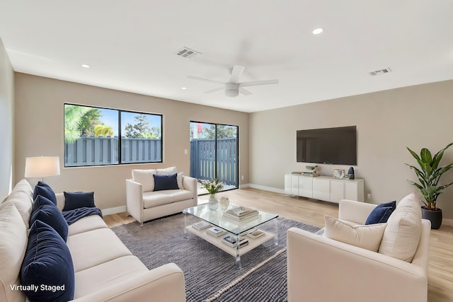 living room featuring light hardwood / wood-style floors and ceiling fan