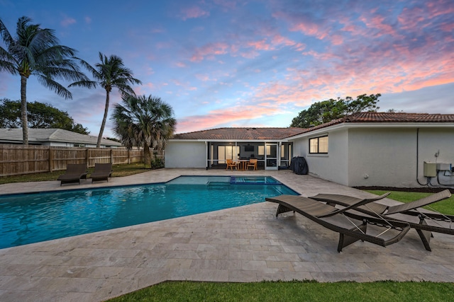 pool at dusk with a patio