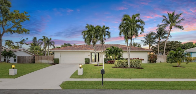 single story home with a garage and a yard