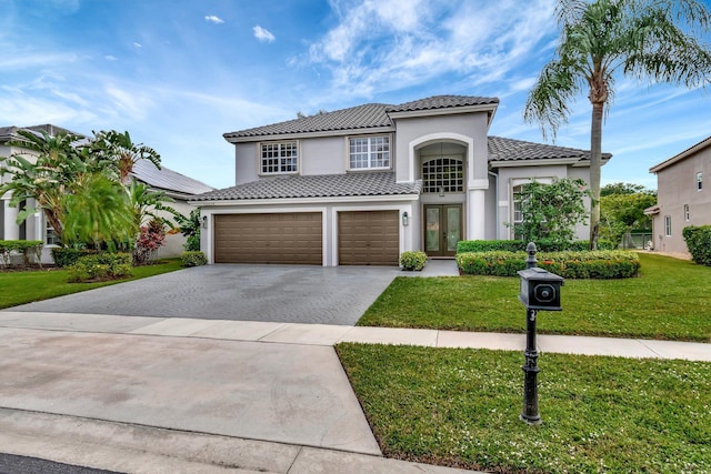 mediterranean / spanish-style home with a front yard, french doors, and a garage