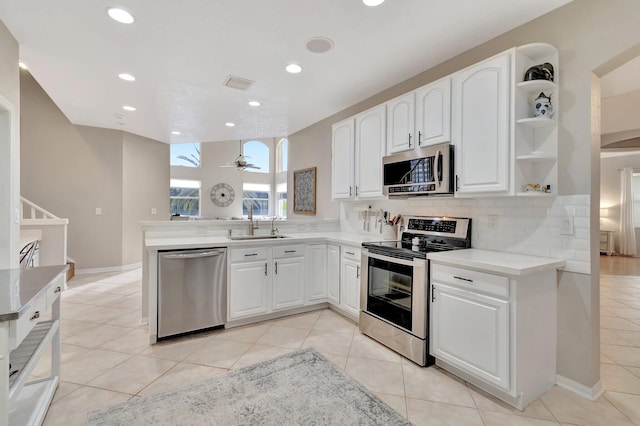 kitchen with white cabinets, backsplash, sink, and stainless steel appliances