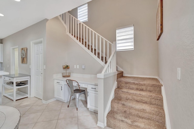 stairs featuring built in desk and tile patterned floors