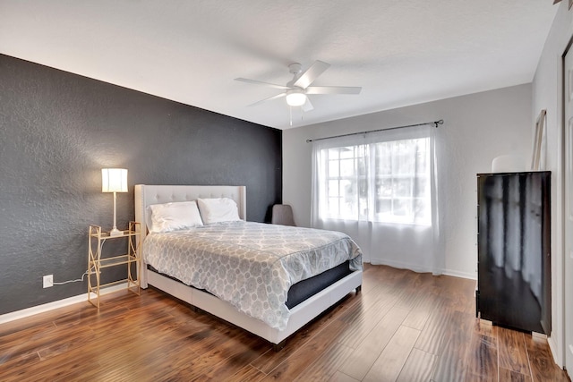 bedroom with dark hardwood / wood-style floors and ceiling fan