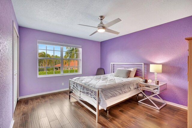 bedroom featuring hardwood / wood-style flooring, ceiling fan, and a textured ceiling