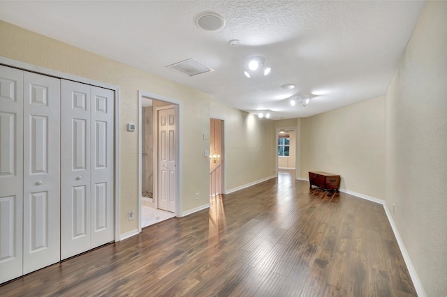 interior space with dark hardwood / wood-style flooring and a textured ceiling