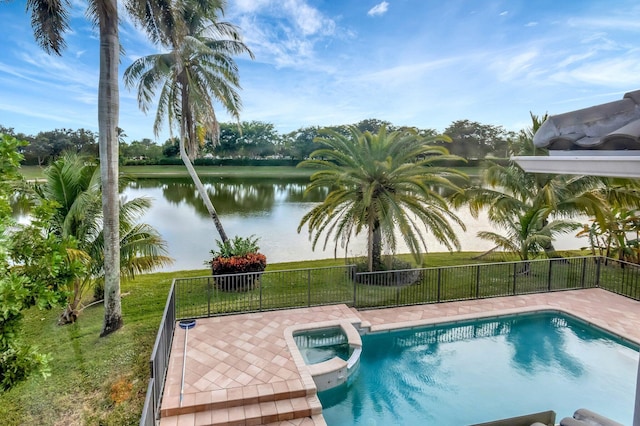 view of swimming pool featuring an in ground hot tub, a yard, and a water view