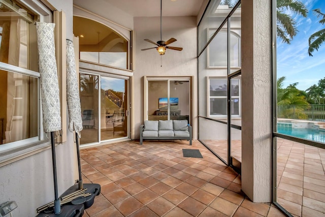 unfurnished sunroom with ceiling fan