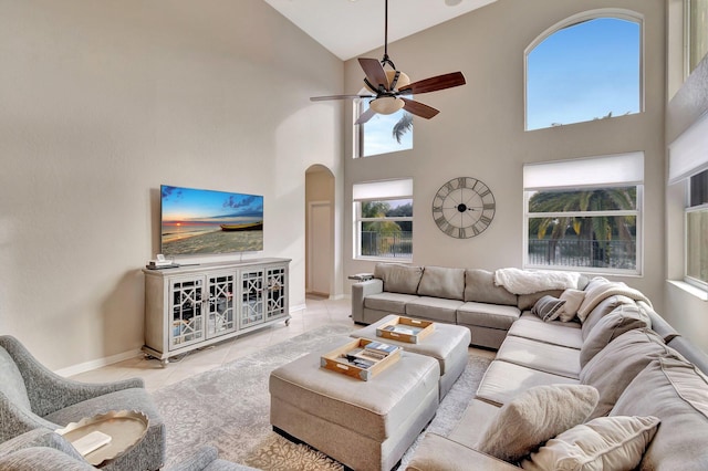 tiled living room featuring high vaulted ceiling and ceiling fan