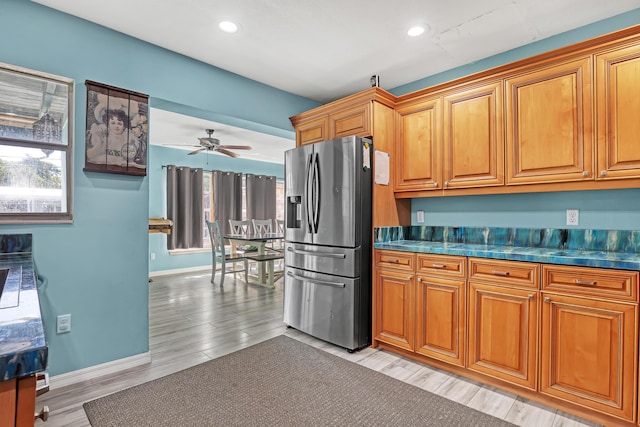 kitchen featuring stainless steel fridge with ice dispenser, light hardwood / wood-style flooring, and ceiling fan