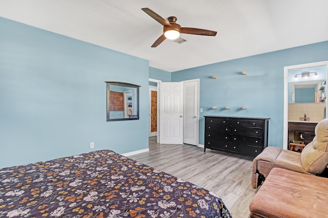 bedroom featuring ensuite bathroom, light hardwood / wood-style flooring, and ceiling fan