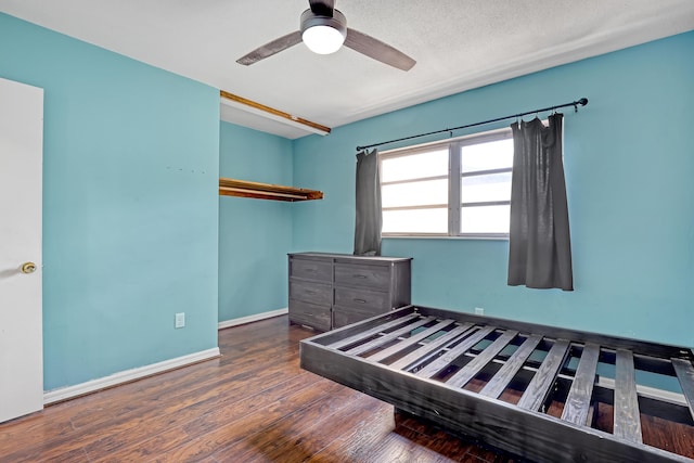 bedroom with ceiling fan, dark hardwood / wood-style floors, and a textured ceiling