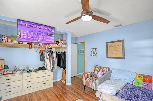 bedroom featuring ceiling fan, dark hardwood / wood-style flooring, and a closet