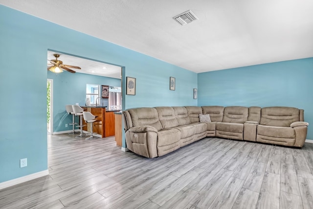 living room featuring ceiling fan and light hardwood / wood-style flooring