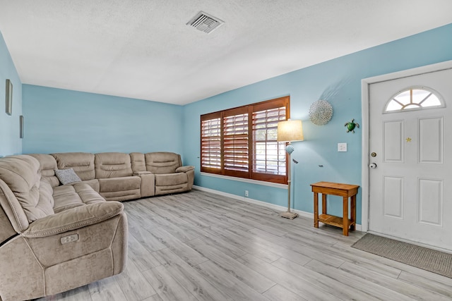 living room featuring a textured ceiling and light hardwood / wood-style flooring