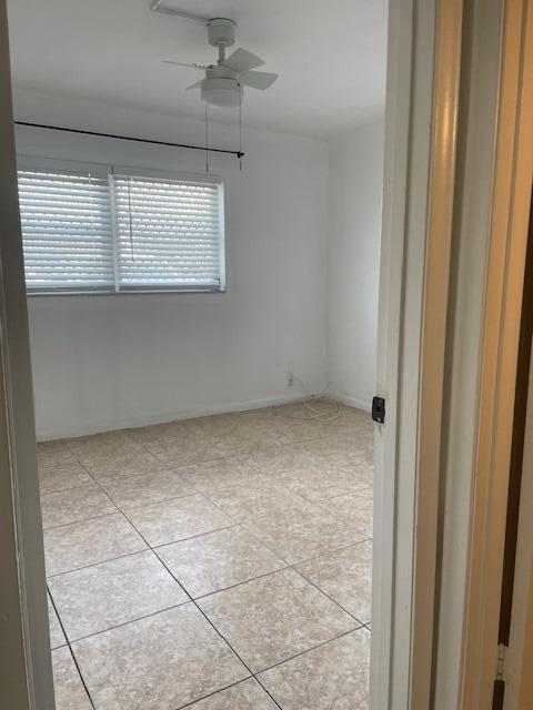 tiled empty room with ceiling fan