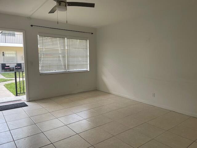 unfurnished room with light tile patterned floors and ceiling fan