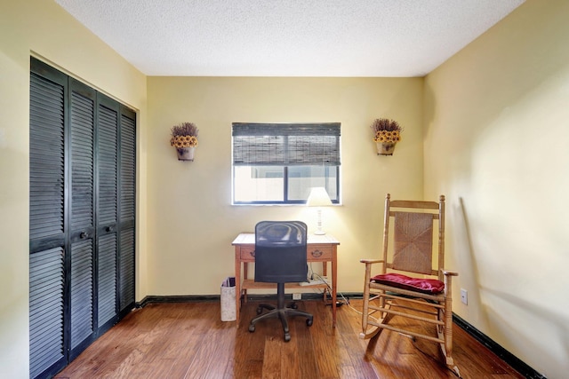 office area with hardwood / wood-style floors and a textured ceiling