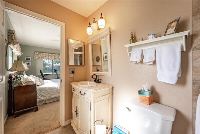 bathroom with vanity, toilet, and a textured ceiling