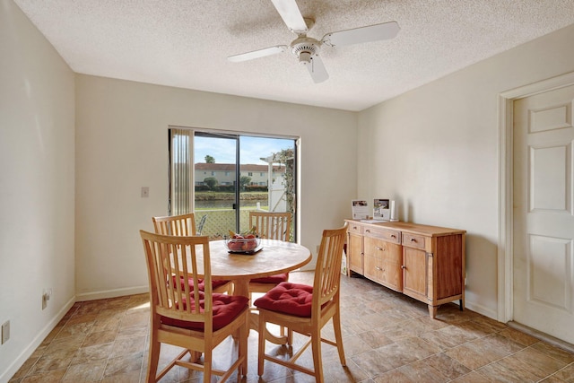 dining space with ceiling fan and a textured ceiling