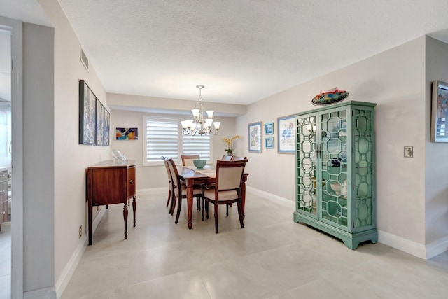 dining room with a textured ceiling and an inviting chandelier