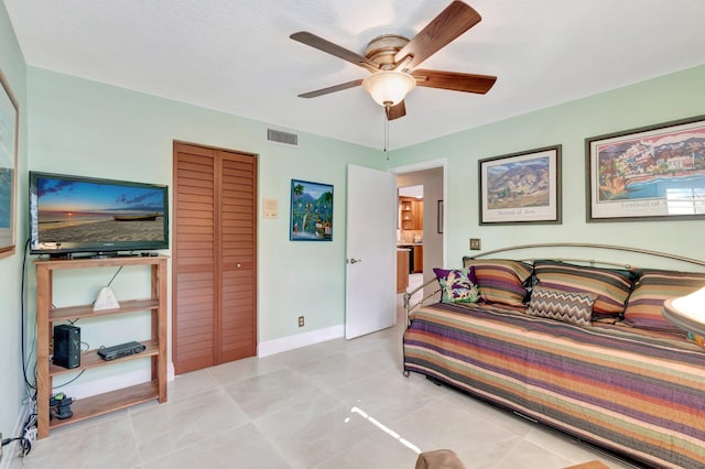 tiled bedroom featuring a closet and ceiling fan