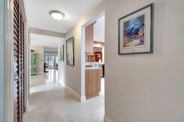 hallway with sink and a textured ceiling