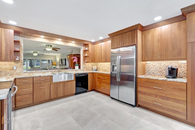 kitchen featuring dishwasher, backsplash, sink, stainless steel fridge, and light stone countertops