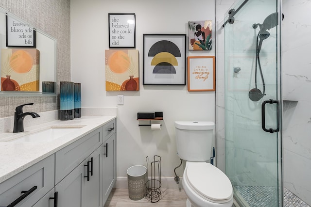 bathroom with vanity, a shower with shower door, and toilet