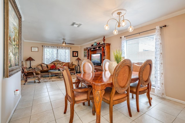 tiled dining space with a wealth of natural light, crown molding, and ceiling fan with notable chandelier