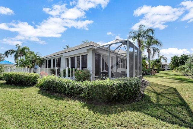 back of property with a yard and a lanai