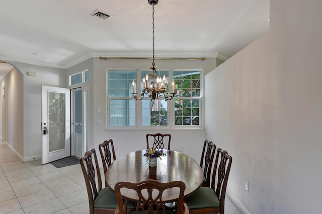 tiled dining room featuring crown molding, french doors, and an inviting chandelier