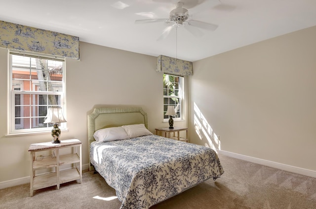 carpeted bedroom featuring multiple windows and ceiling fan