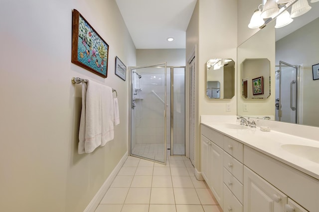 bathroom featuring tile patterned flooring, vanity, and a shower with shower door