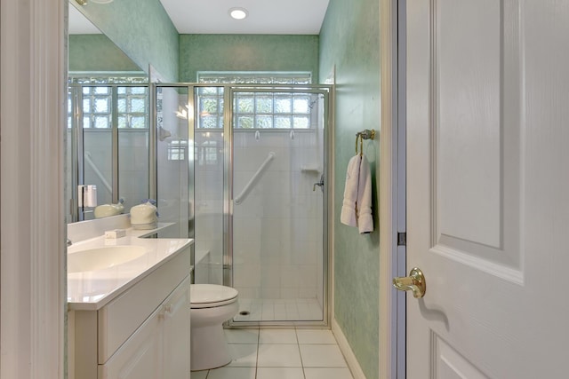 bathroom with tile patterned flooring, vanity, toilet, and walk in shower