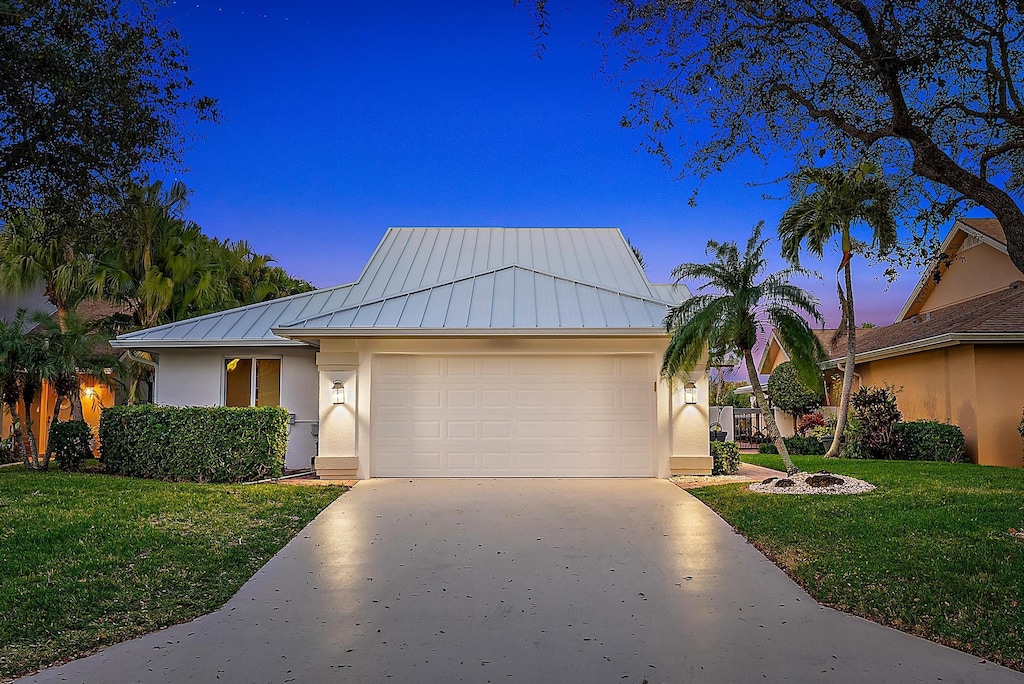 view of front of house featuring a yard and a garage