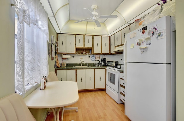 kitchen with light wood-type flooring, white appliances, ceiling fan, and sink