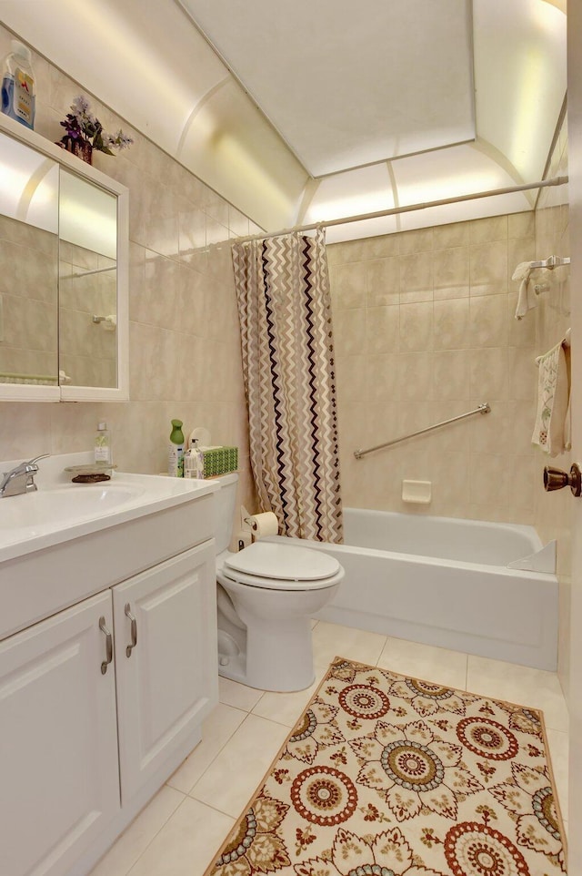 full bathroom featuring shower / bath combo, tile patterned flooring, toilet, vanity, and tile walls